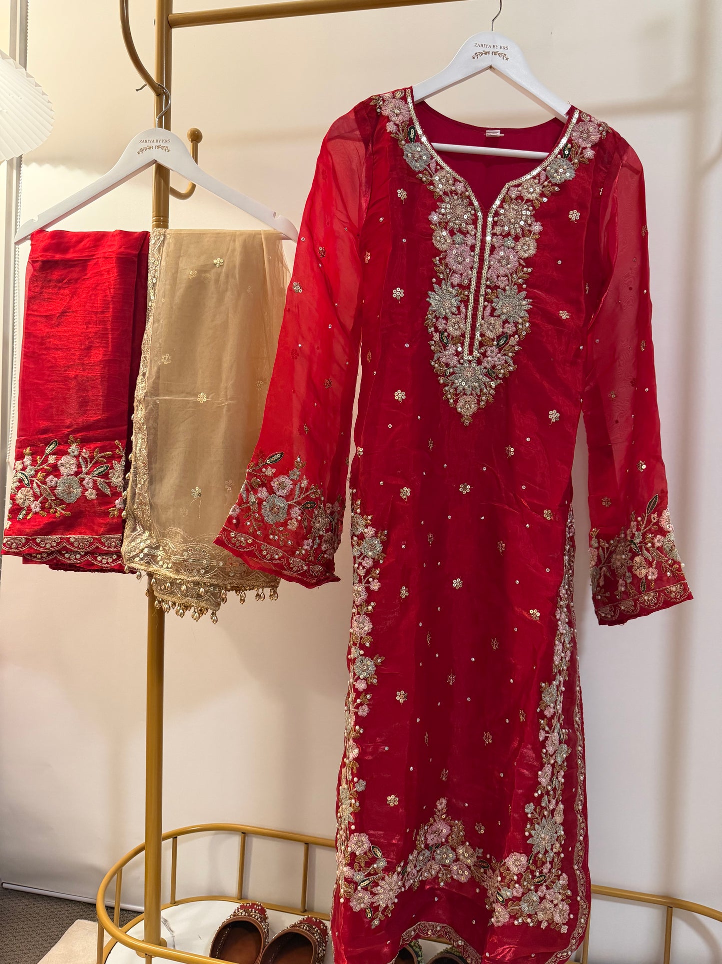 Red embroidered traditional outfit with red pants and golden dupatta.